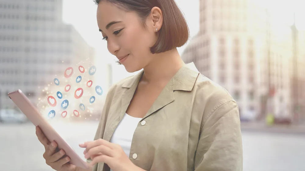 uma mulher asiática com um tablet na mão live marketing